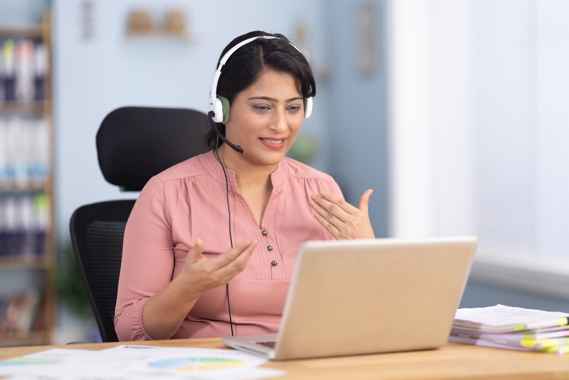 Woman wearing headset have meeting online, video conferencing stock photo